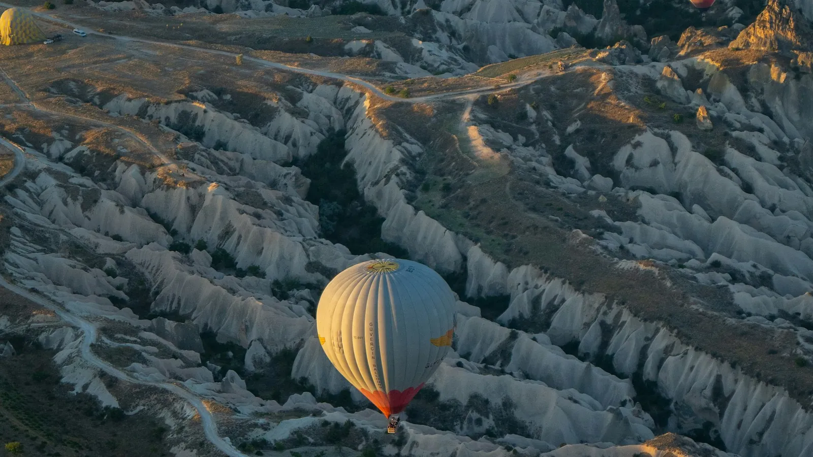 Hot air balloons at sunrise over the valleys surrounding Uçhisar, Cappadocia